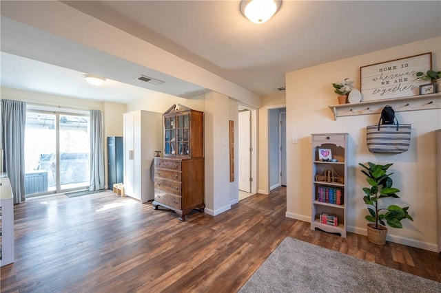 interior space featuring wood finished floors, visible vents, and baseboards