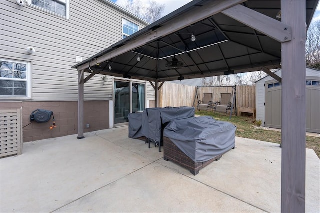 view of patio / terrace featuring a gazebo, a storage shed, an outdoor structure, and fence