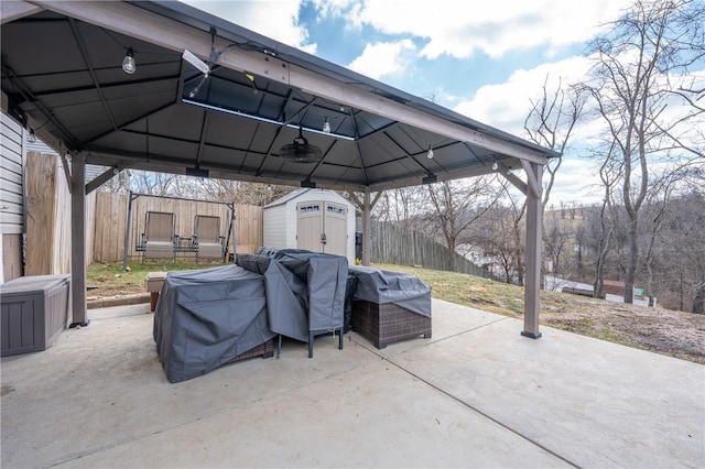 view of patio featuring fence, a gazebo, a storage shed, an outbuilding, and area for grilling