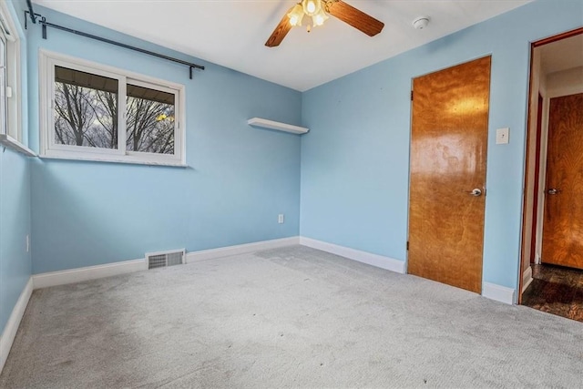 spare room featuring visible vents, baseboards, carpet flooring, and a ceiling fan