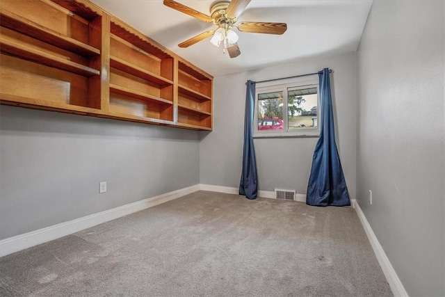 unfurnished room featuring carpet flooring, baseboards, visible vents, and ceiling fan