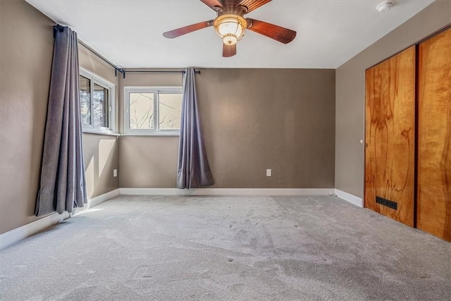 empty room with baseboards, carpet, and a ceiling fan