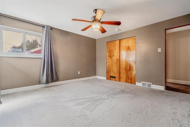 unfurnished bedroom with visible vents, carpet flooring, a ceiling fan, and baseboards