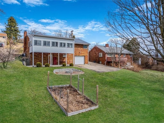 back of house featuring brick siding, a yard, a garage, driveway, and a vegetable garden