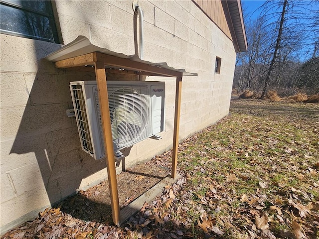 view of property exterior with concrete block siding and ac unit