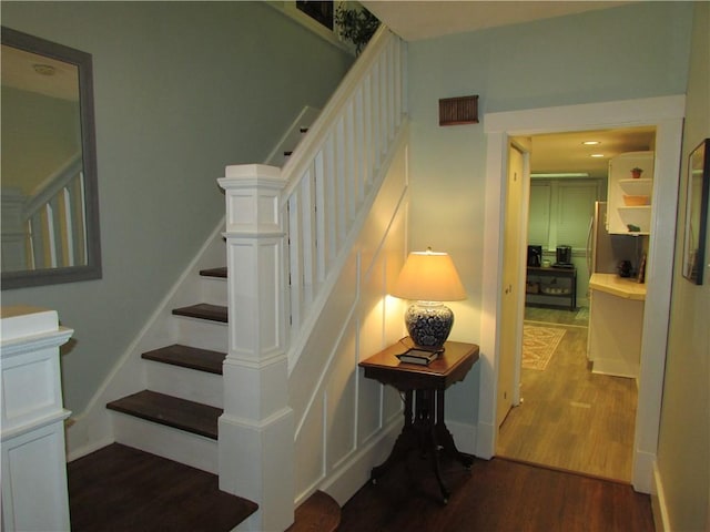 stairs with wood finished floors and baseboards