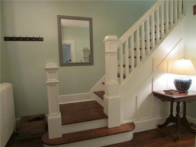 staircase with baseboards and wood finished floors