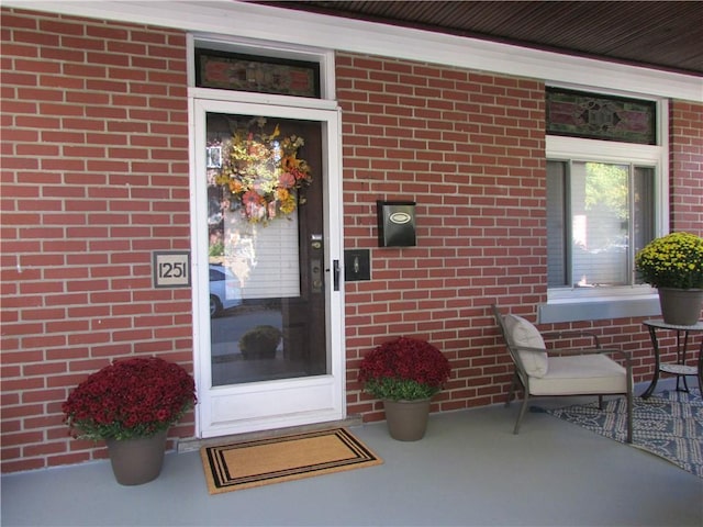 view of exterior entry featuring brick siding