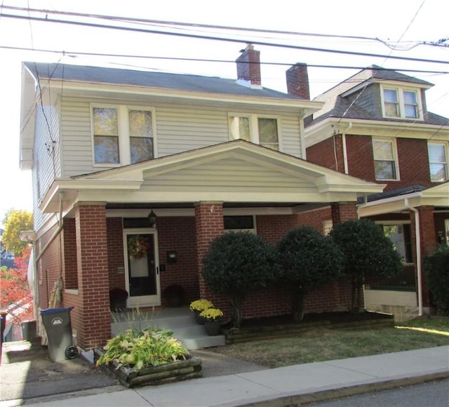 view of front of house featuring brick siding and a chimney