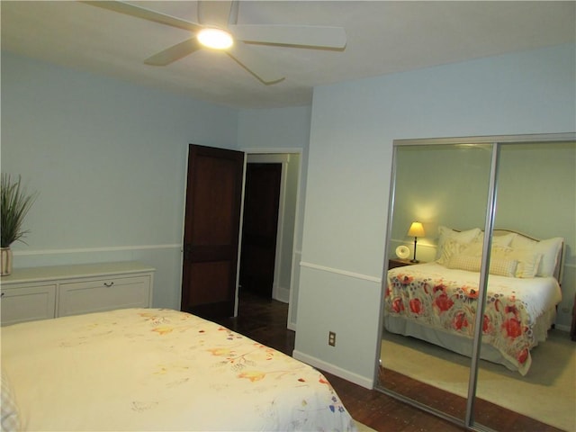 bedroom with dark wood finished floors, a ceiling fan, a closet, and baseboards