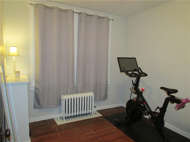 exercise room with baseboards, wood finished floors, and radiator heating unit