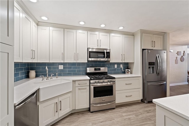 kitchen with decorative backsplash, appliances with stainless steel finishes, light countertops, and a sink