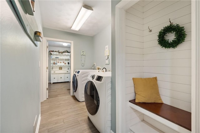 laundry area featuring light wood finished floors, laundry area, and washing machine and dryer