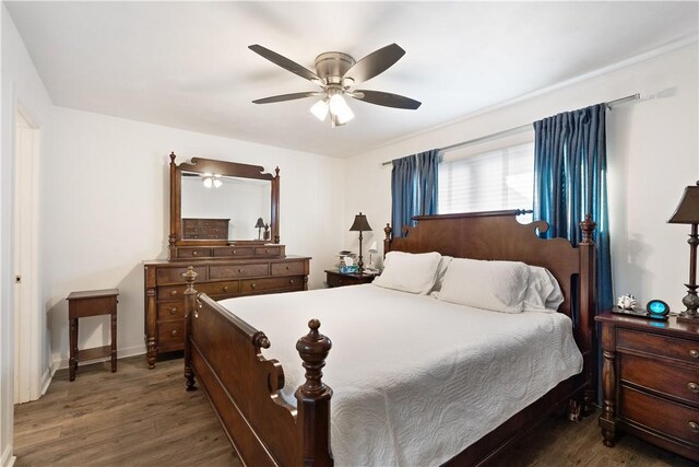 bedroom with ceiling fan, baseboards, and wood finished floors