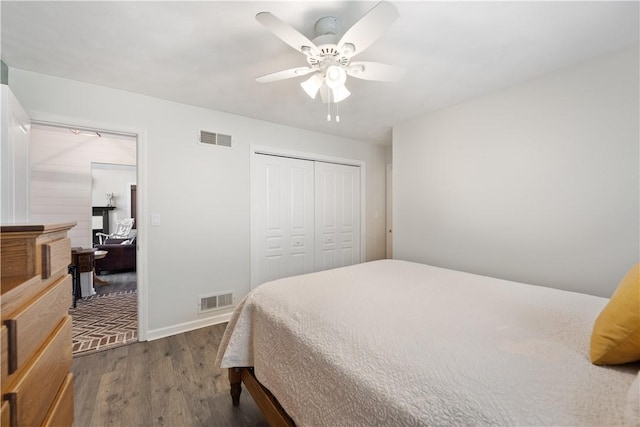 bedroom with a closet, a ceiling fan, visible vents, and dark wood-style flooring