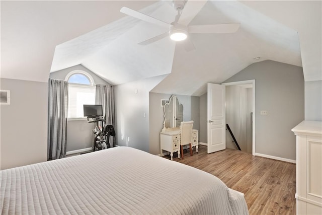 bedroom with a ceiling fan, vaulted ceiling, wood finished floors, and baseboards