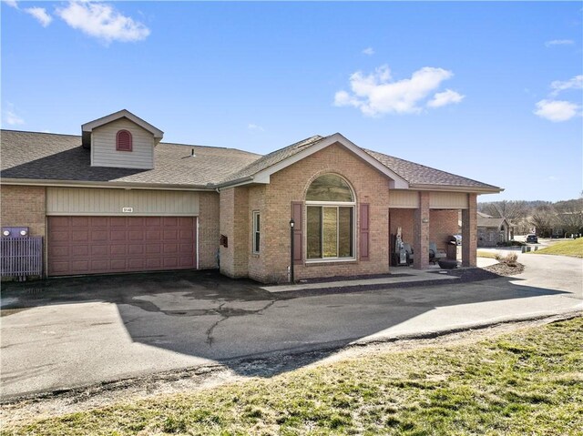 view of front of home with a garage, brick siding, driveway, and a shingled roof