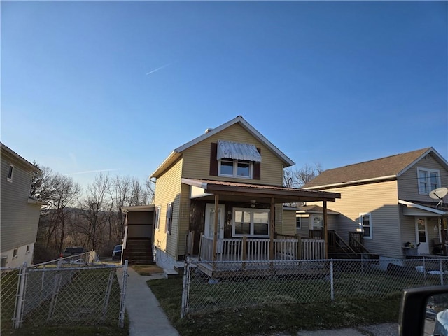 view of front of house with a fenced front yard, covered porch, a front lawn, and a gate