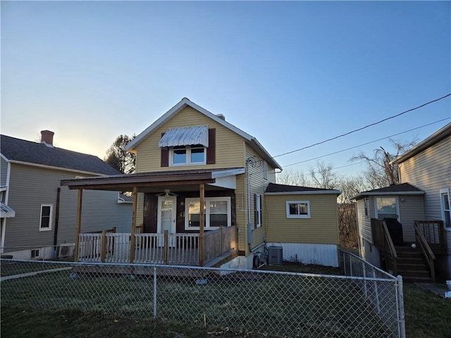 view of front of house featuring covered porch, fence private yard, and central AC