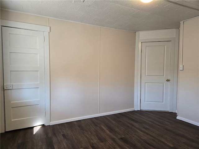 spare room with dark wood finished floors and baseboards