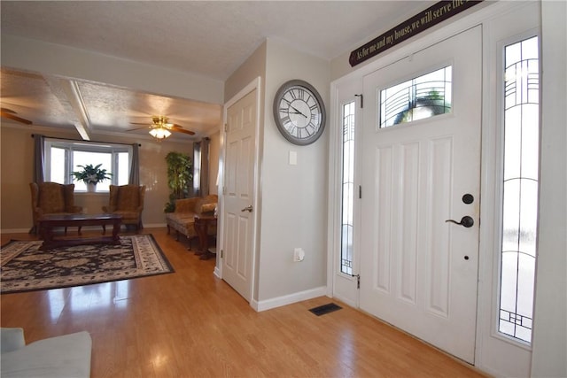 entrance foyer with light wood-type flooring, baseboards, visible vents, and ceiling fan