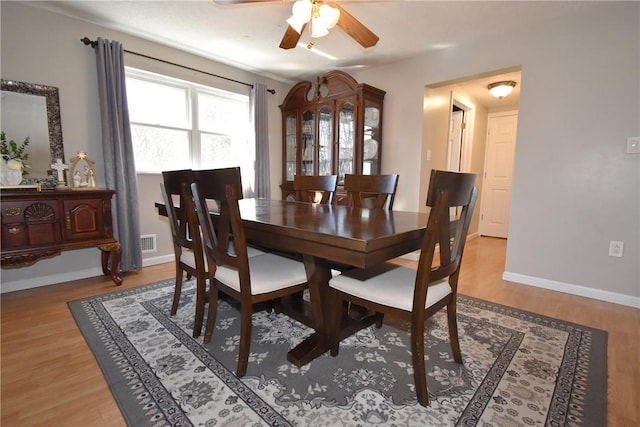 dining area with ceiling fan, visible vents, baseboards, and wood finished floors