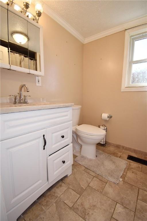 full bath featuring toilet, a textured ceiling, crown molding, baseboards, and vanity