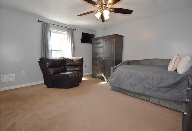 bedroom with visible vents, light carpet, a textured ceiling, and baseboards