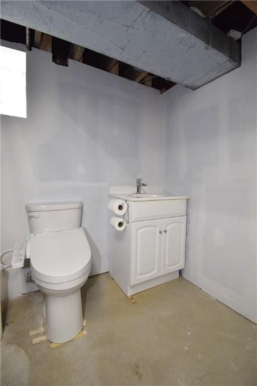 bathroom with vanity, toilet, and concrete floors