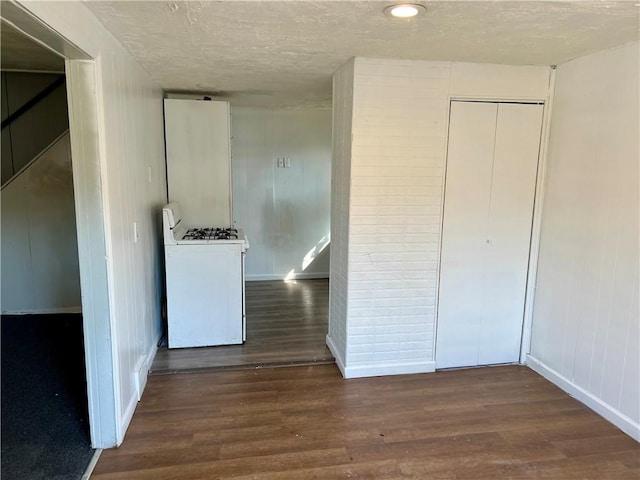 interior space with stairway, wood finished floors, baseboards, and a textured ceiling