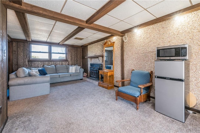 carpeted living room with a paneled ceiling, beam ceiling, and a fireplace