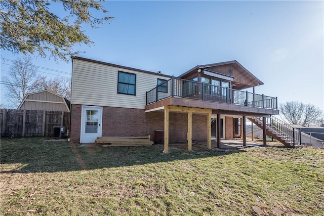 rear view of house with a lawn, a deck, fence, stairway, and brick siding