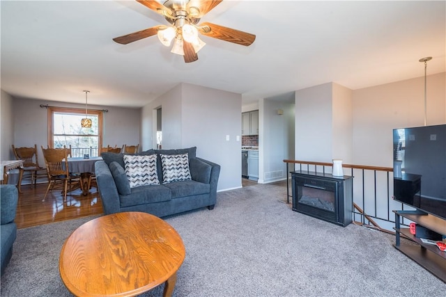 carpeted living area featuring ceiling fan