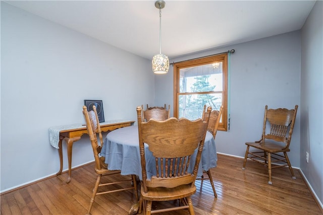 dining space with baseboards and light wood finished floors