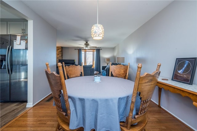 dining area with visible vents, baseboards, a ceiling fan, and wood finished floors