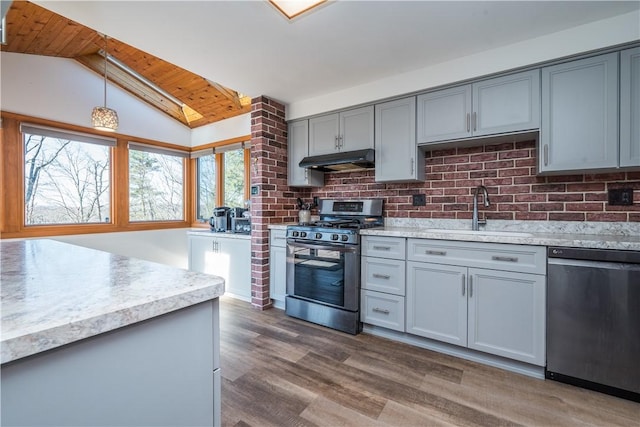 kitchen featuring dishwashing machine, stainless steel range with gas cooktop, gray cabinets, a sink, and under cabinet range hood