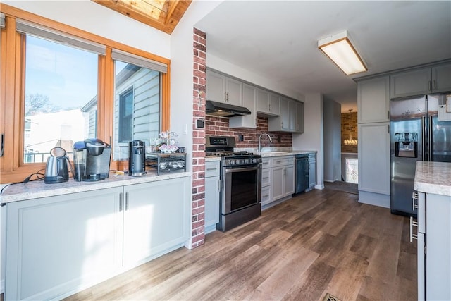 kitchen featuring under cabinet range hood, gas range, dishwasher, refrigerator with ice dispenser, and gray cabinets