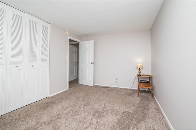 unfurnished bedroom featuring a closet, baseboards, and carpet