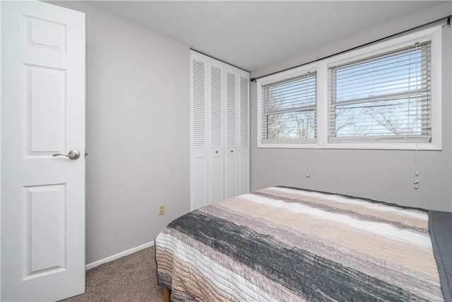 bedroom featuring a closet, baseboards, and carpet