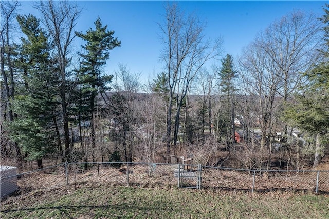 view of yard with a wooded view and fence