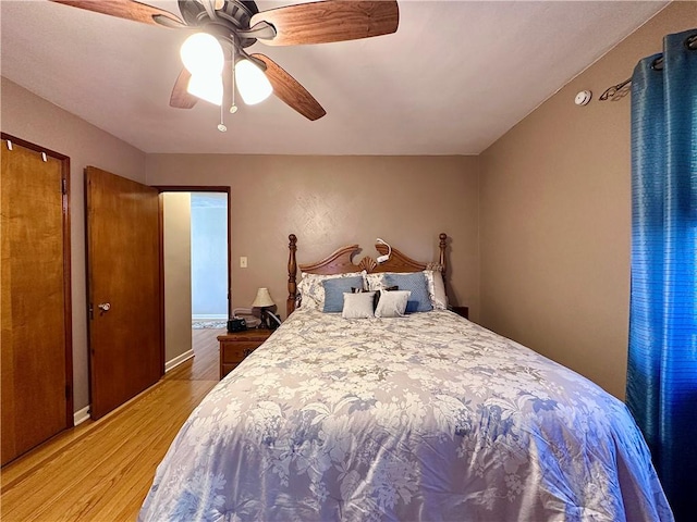 bedroom with light wood-type flooring, baseboards, and ceiling fan