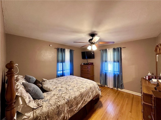 bedroom with baseboards, light wood-type flooring, and ceiling fan