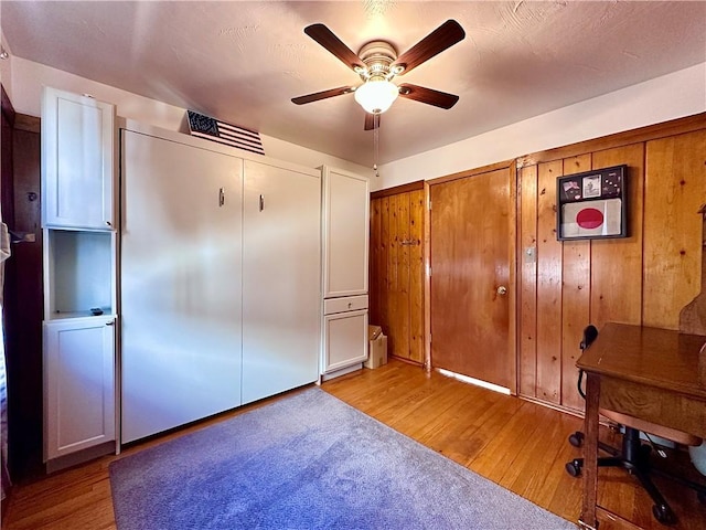 unfurnished office featuring visible vents, ceiling fan, and light wood finished floors