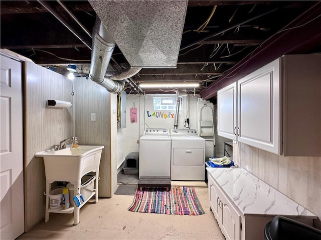 clothes washing area with cabinet space and washing machine and dryer