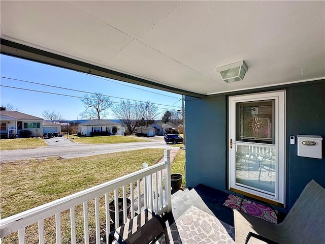 exterior space with a yard, covered porch, a residential view, and stucco siding