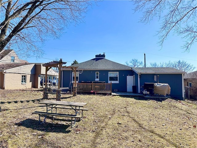 rear view of house featuring roof with shingles, a deck, and a pergola