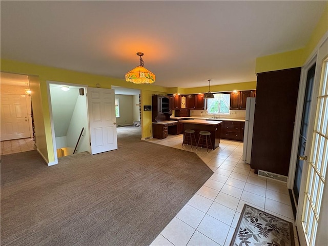 407 Cathedral St, Conemaugh/Young Twps Ind, PA 15681 - kitchen featuring a center island, light countertops, freestanding refrigerator, light tile patterned floors, and pendant lighting