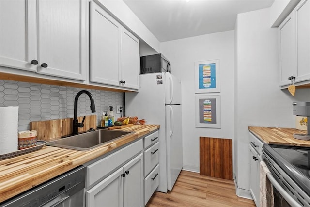 8179 Ohio River Blvd Unit 32, Emsworth, PA 15202 - kitchen with light wood-style flooring, freestanding refrigerator, a sink, wood counters, and stainless steel dishwasher