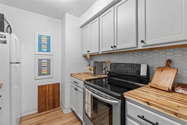 8179 Ohio River Blvd Unit 32, Emsworth, PA 15202 - kitchen featuring stainless steel electric range oven, freestanding refrigerator, tasteful backsplash, light wood-type flooring, and butcher block counters