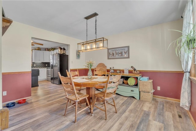 dining area with visible vents, baseboards, and light wood-style flooring